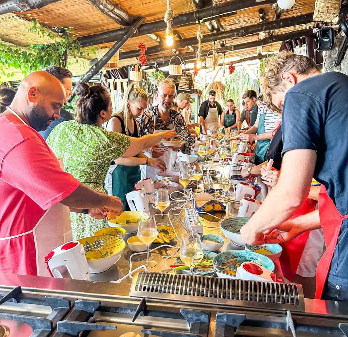 People gathered around a long table preparing food
