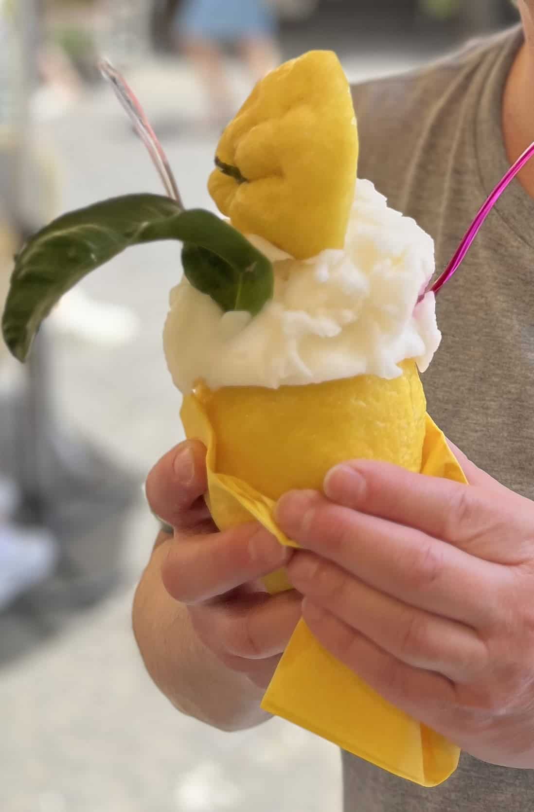 lemon sorbet icream in a lemon cone bottom and lemon top with a spoon