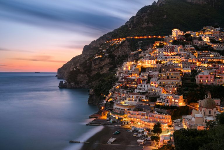 Lights sparkle at night from Positano buildings overlooking the sea
