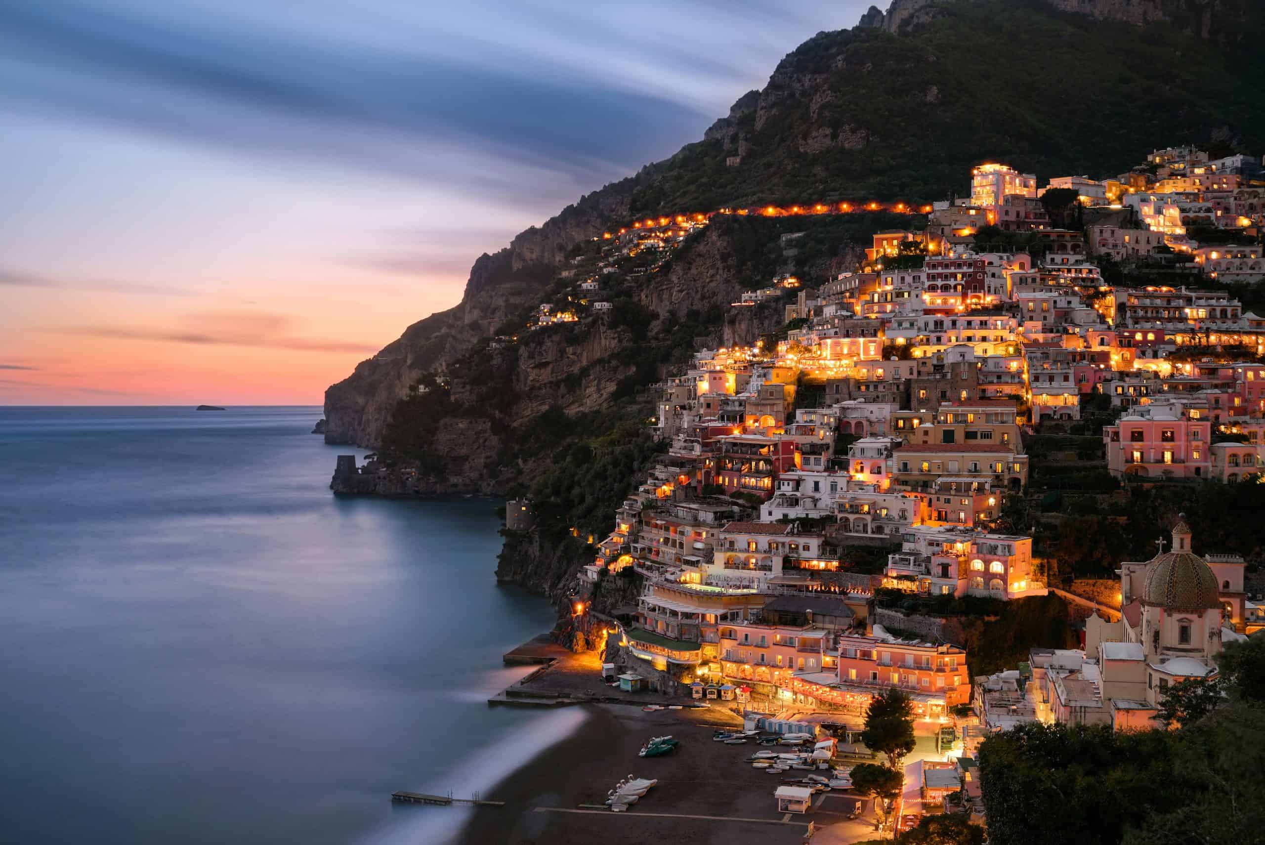 Lights sparkle at night from Positano buildings overlooking the sea
