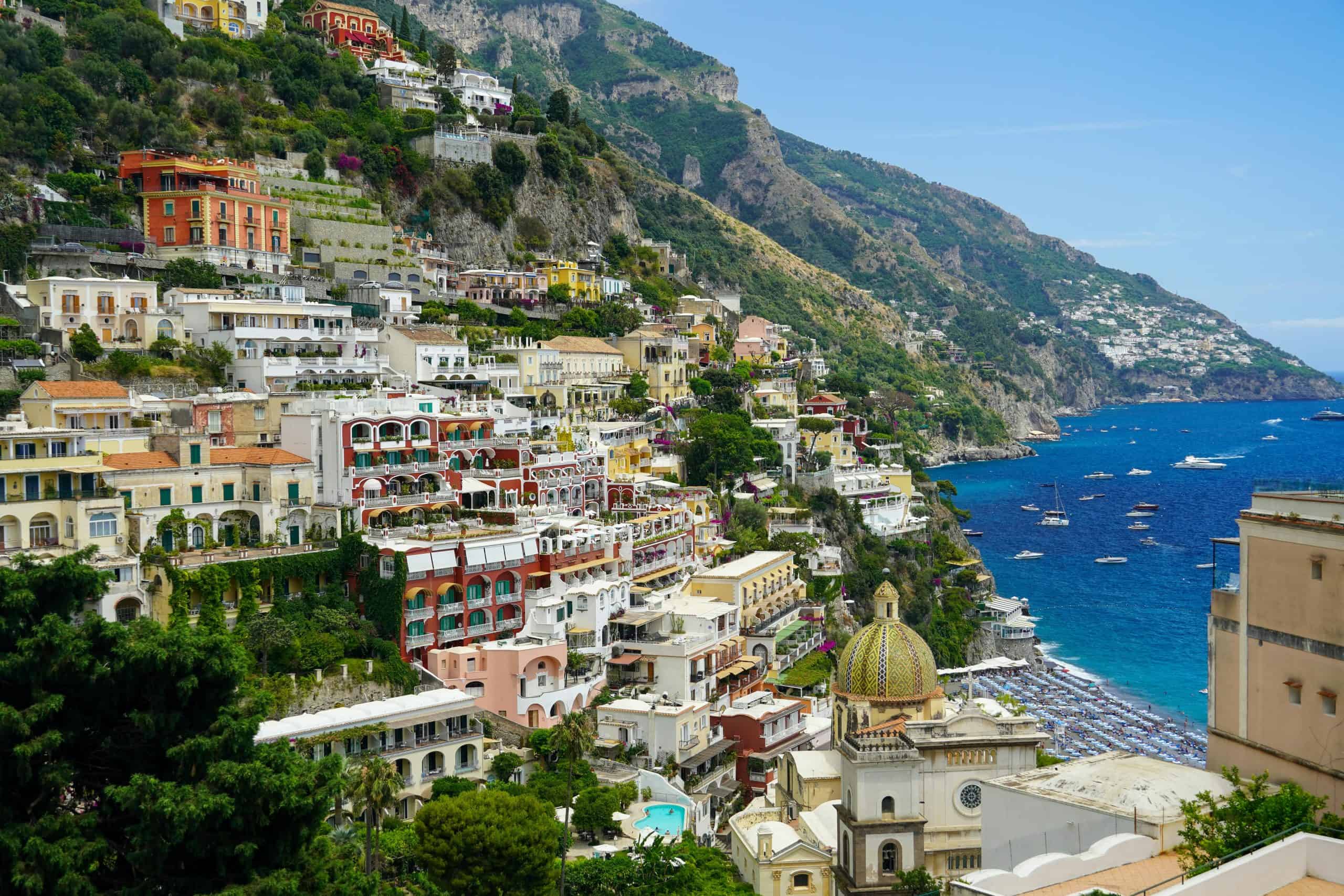 Colorful buildings built into the cliffside with the sea below