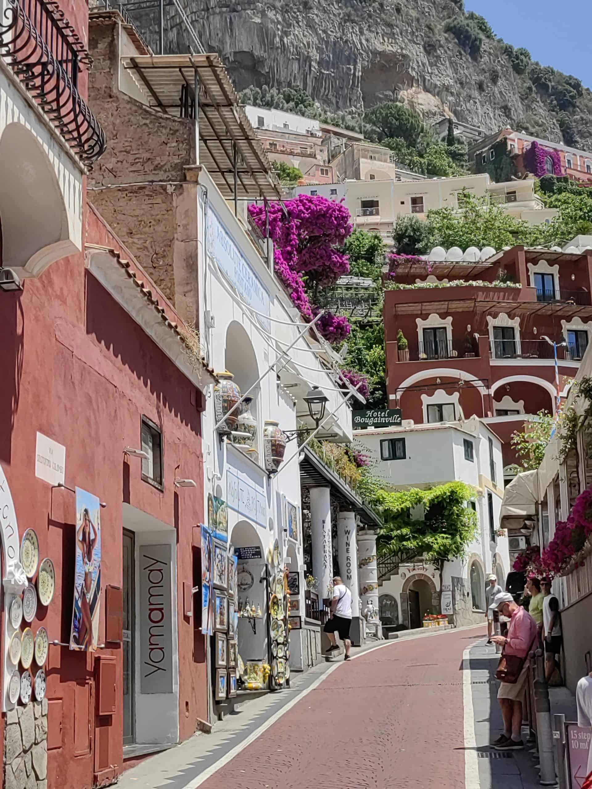 Uphill pedestrian walkway lined with stores in Positano