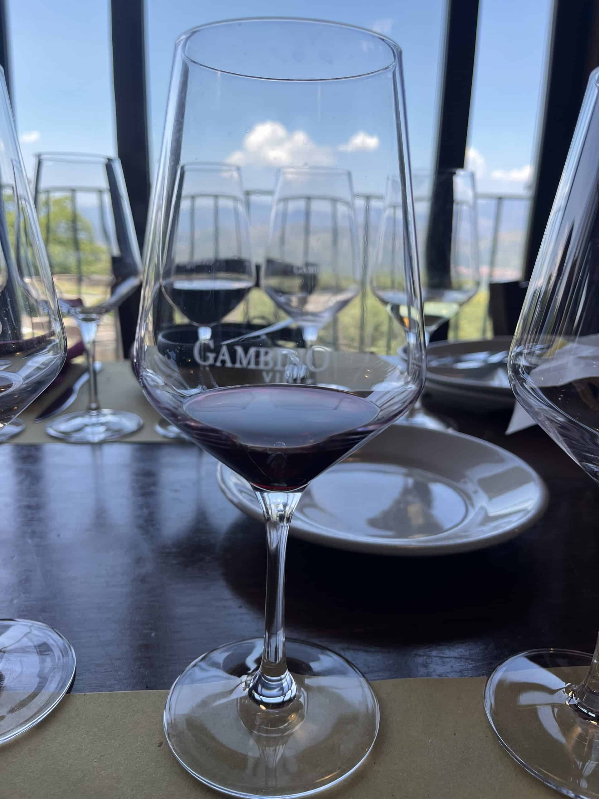 Wine glass with red wine in it and the word Gambino