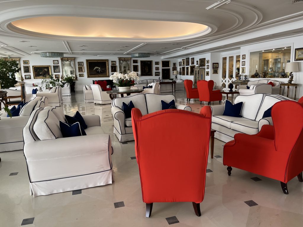 A large seating area of white couches and red chairs