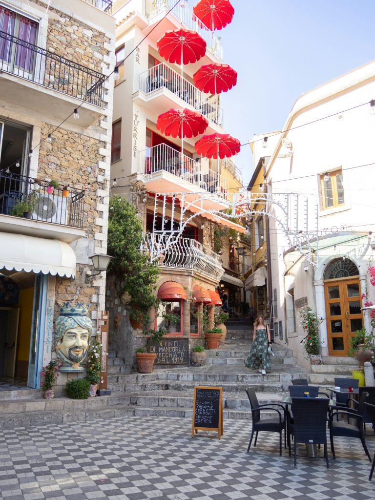 Woman walking down steps in a piazza in Taormina