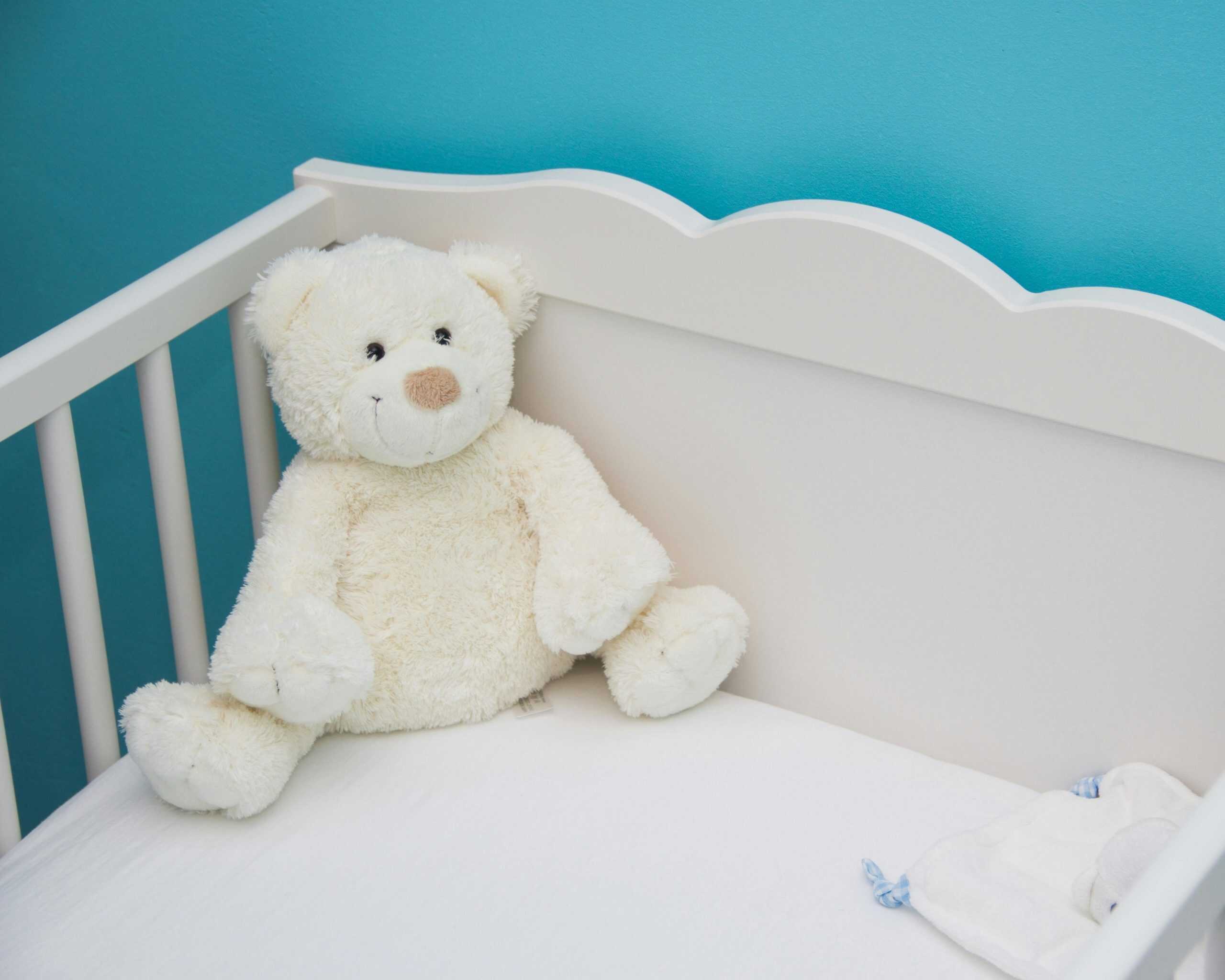 teddy bear sitting in a crib
