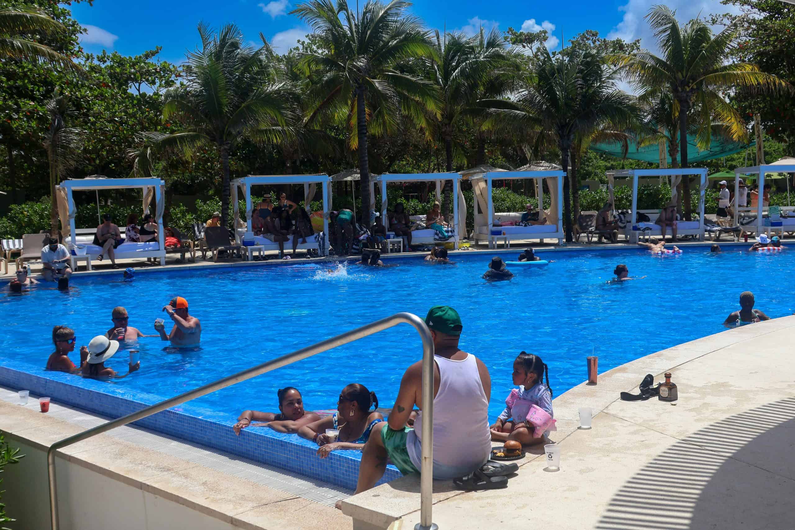 People in a pool with cabanas