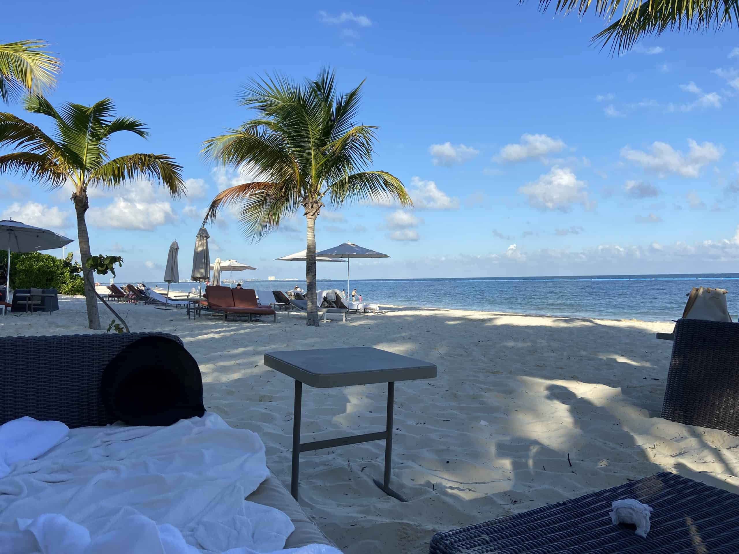 Palm trees on a white sand beach with a table and couch