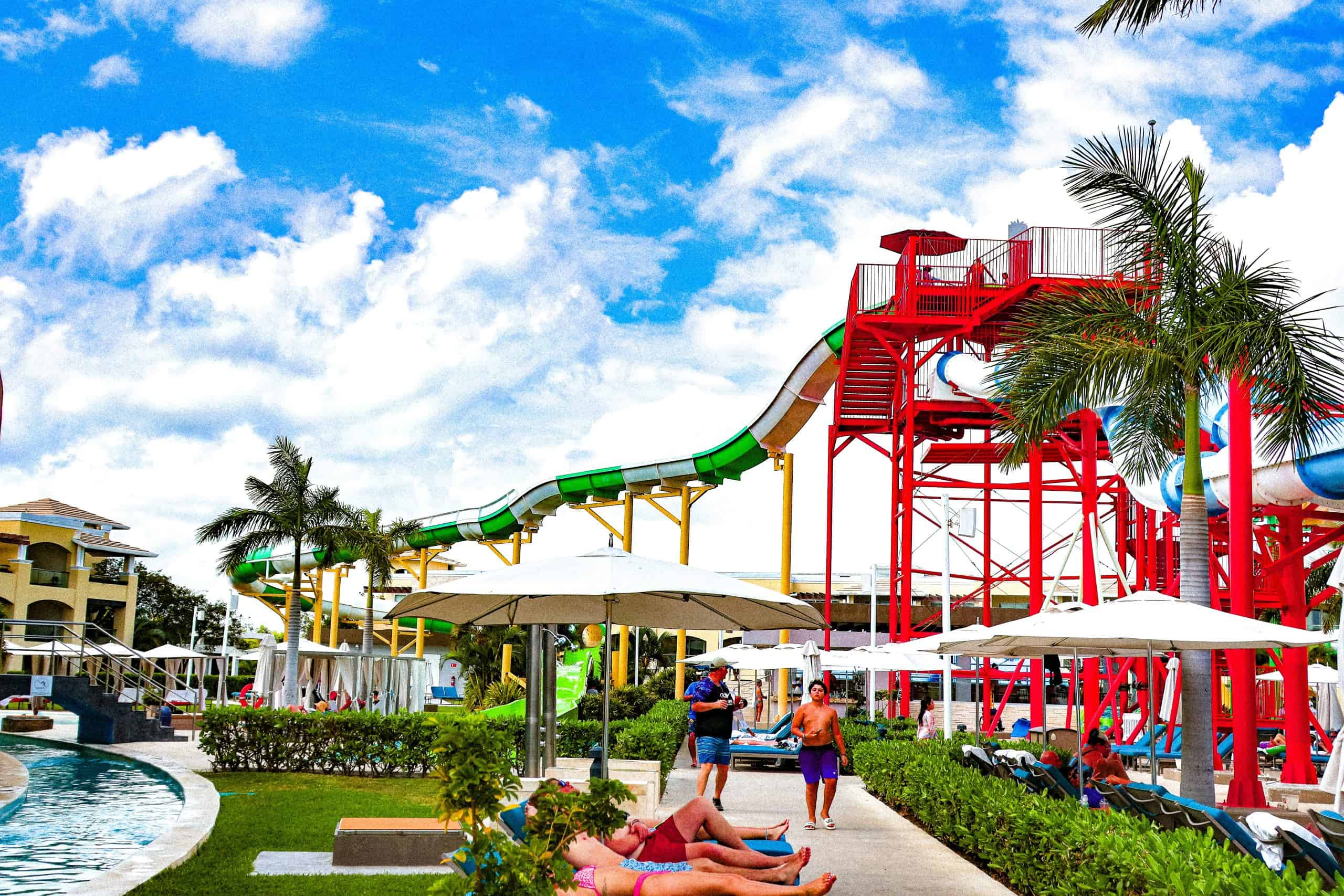 green yellow and red water slides with people walking down below