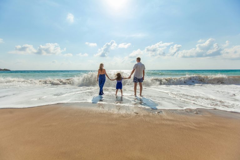 woman child and man walking into the ocean