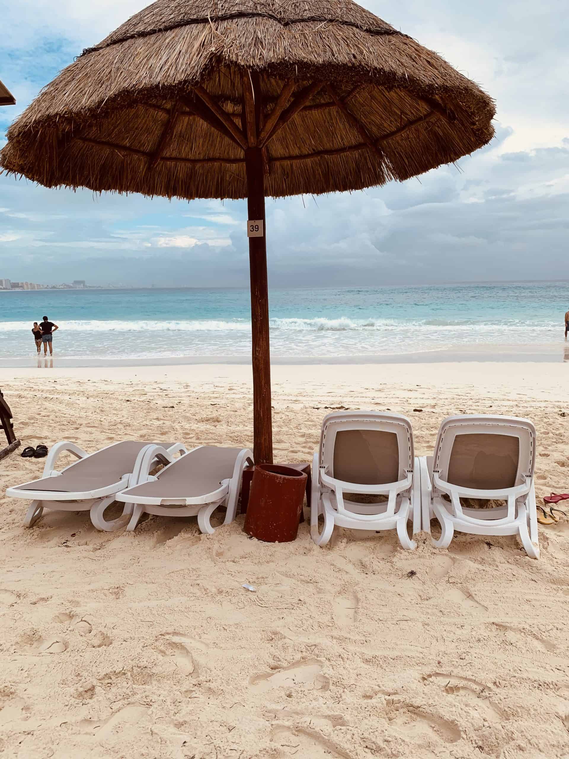 4 chairs under a palapa on the beach