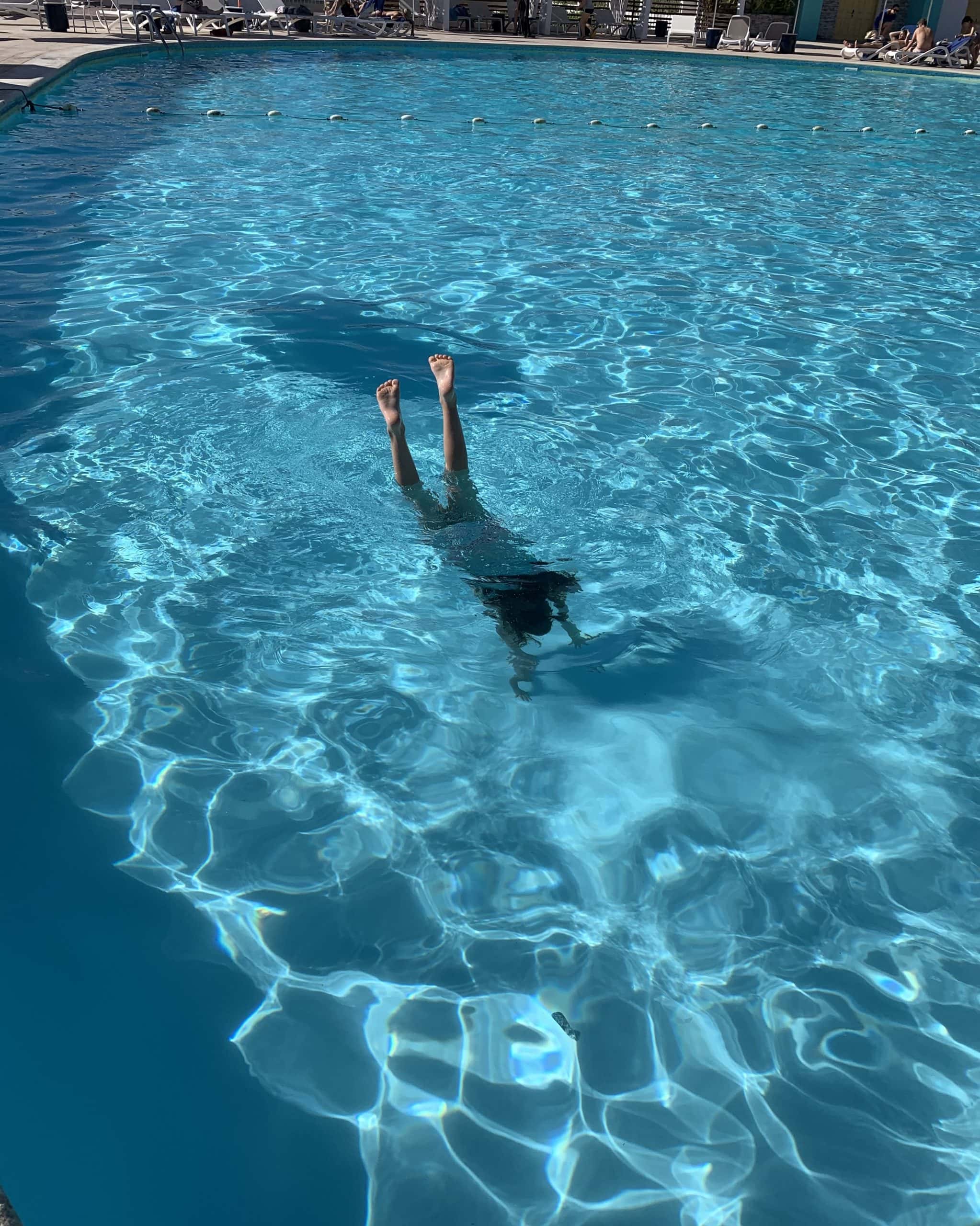 child doing a handstand in a swimming pool