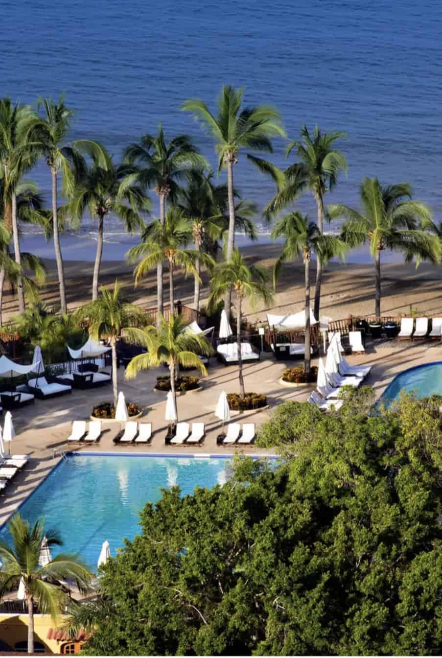 Two pools in a resort with palm trees