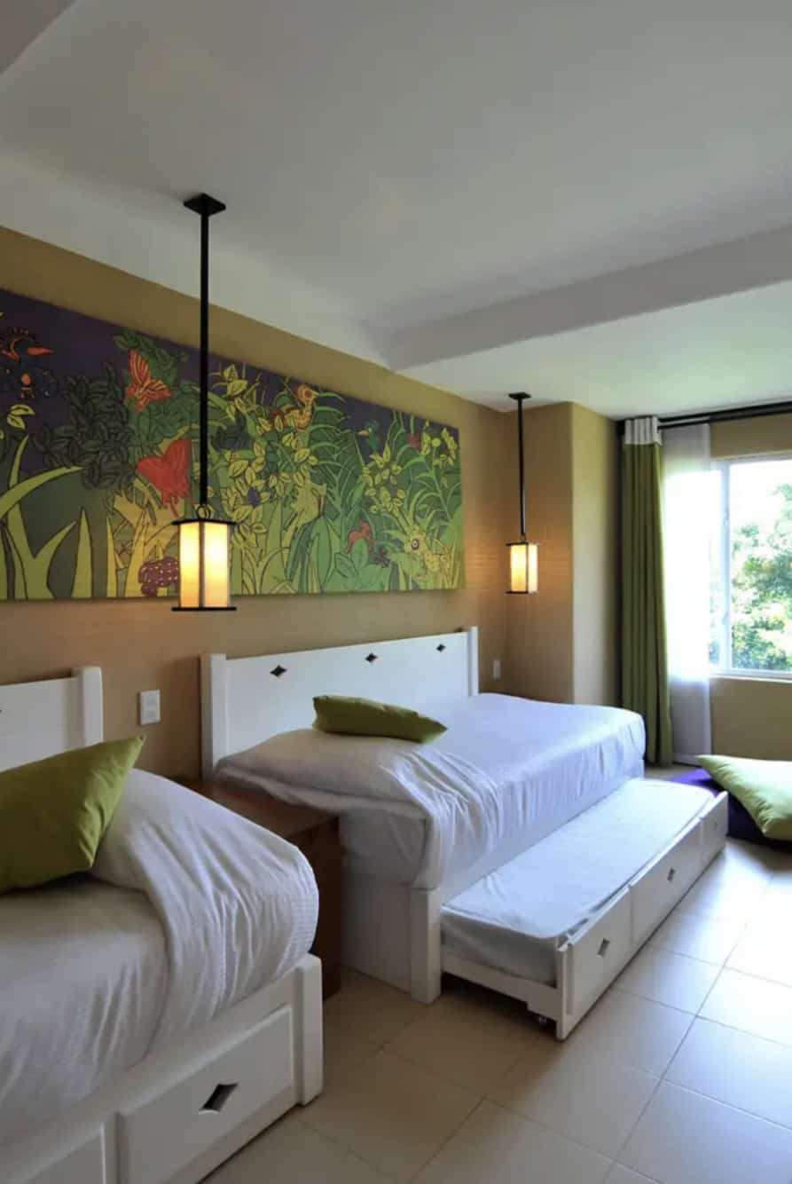 Two twin beds and a trundle bed in a hotel room