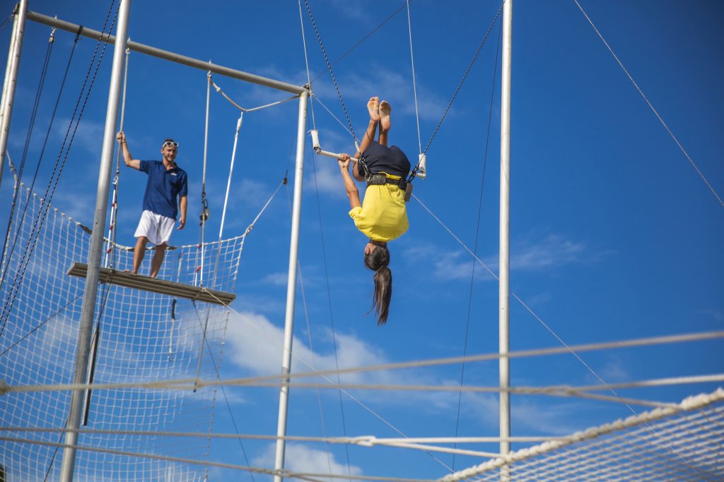 Person hanging upside down on the trapeze