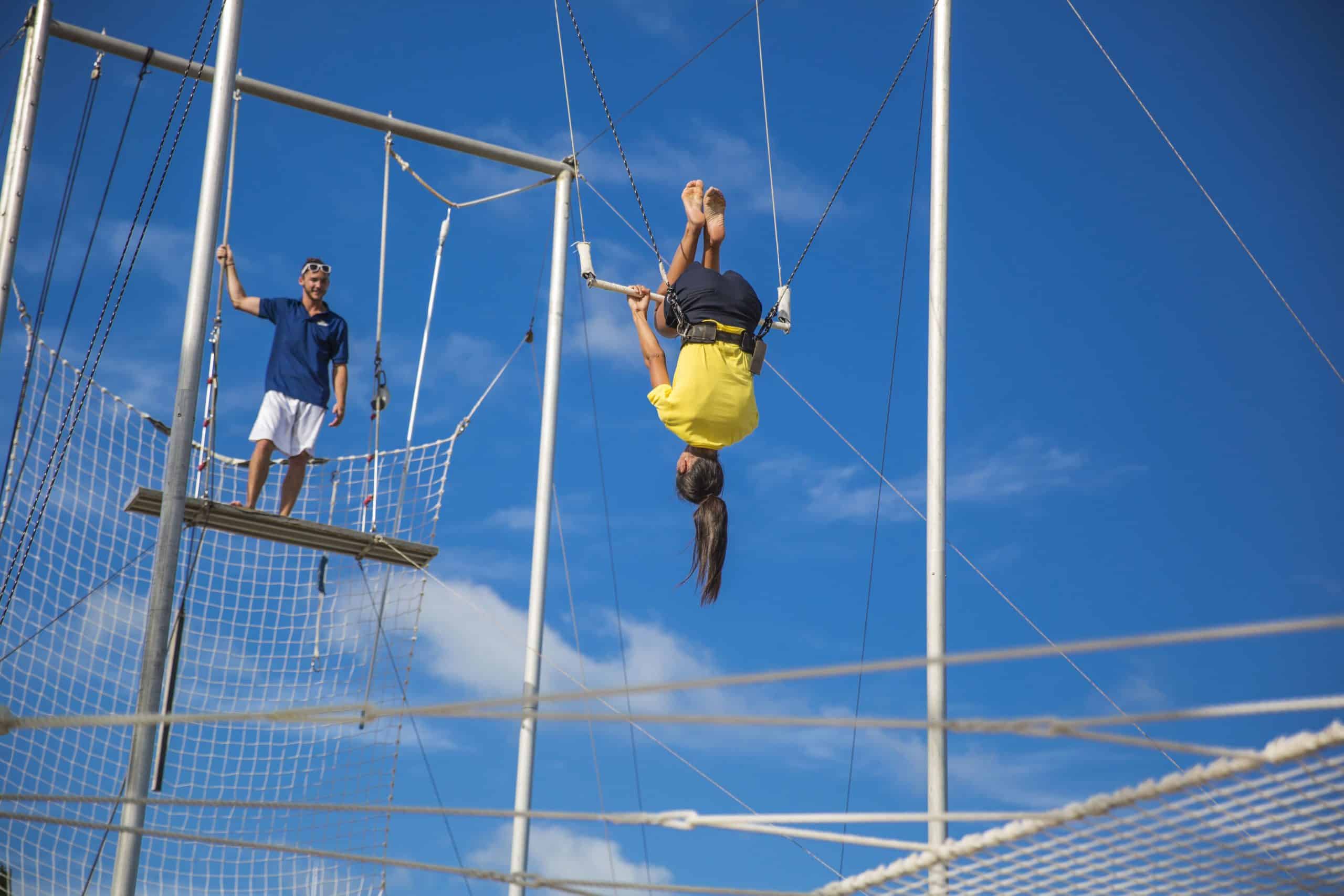 Person hanging upside down on the trapeze