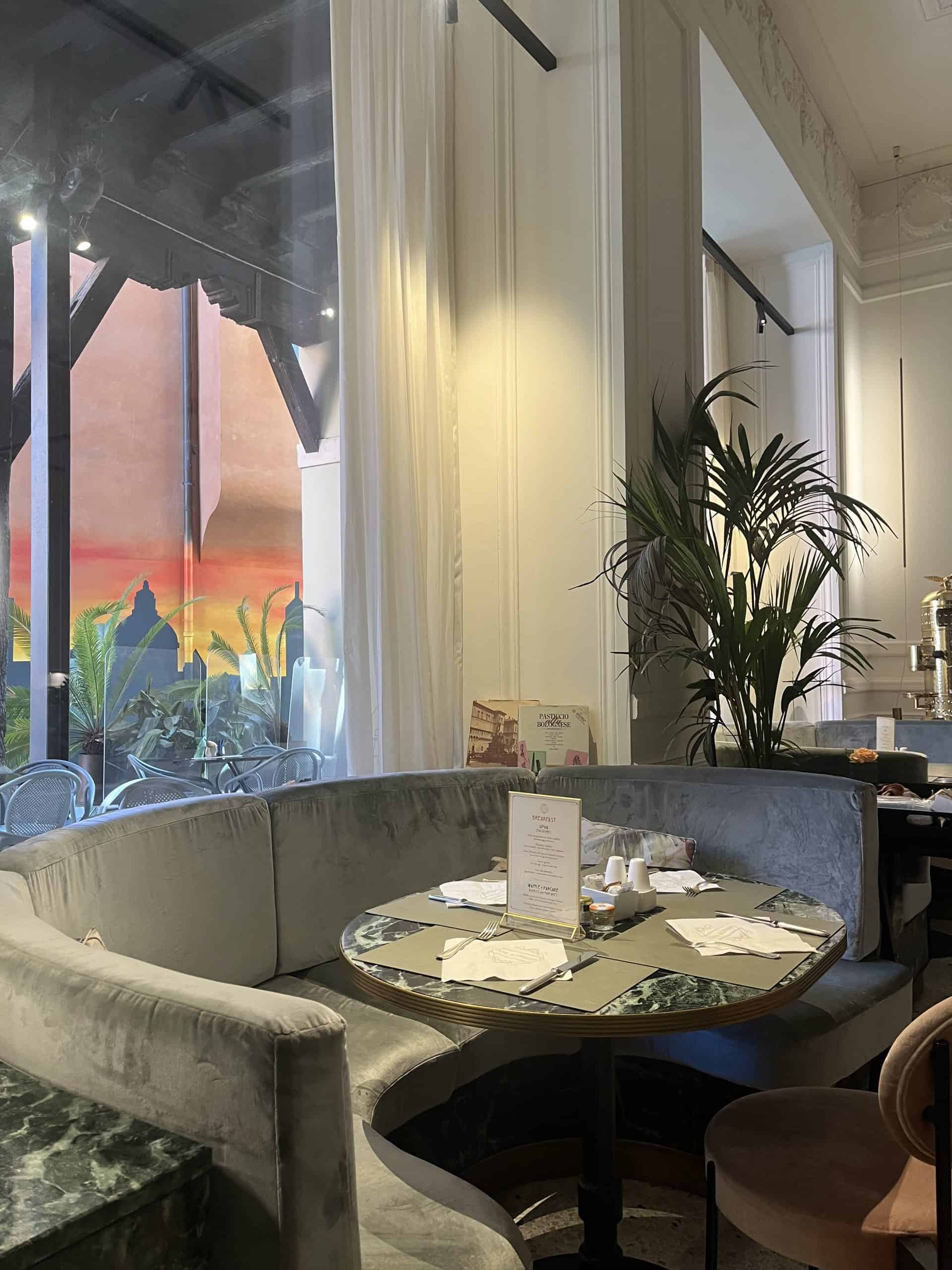 Comfortable hotel restaurant with luxurious decor, large windows, and sunset view, ideal for travelers seeking upscale dining.