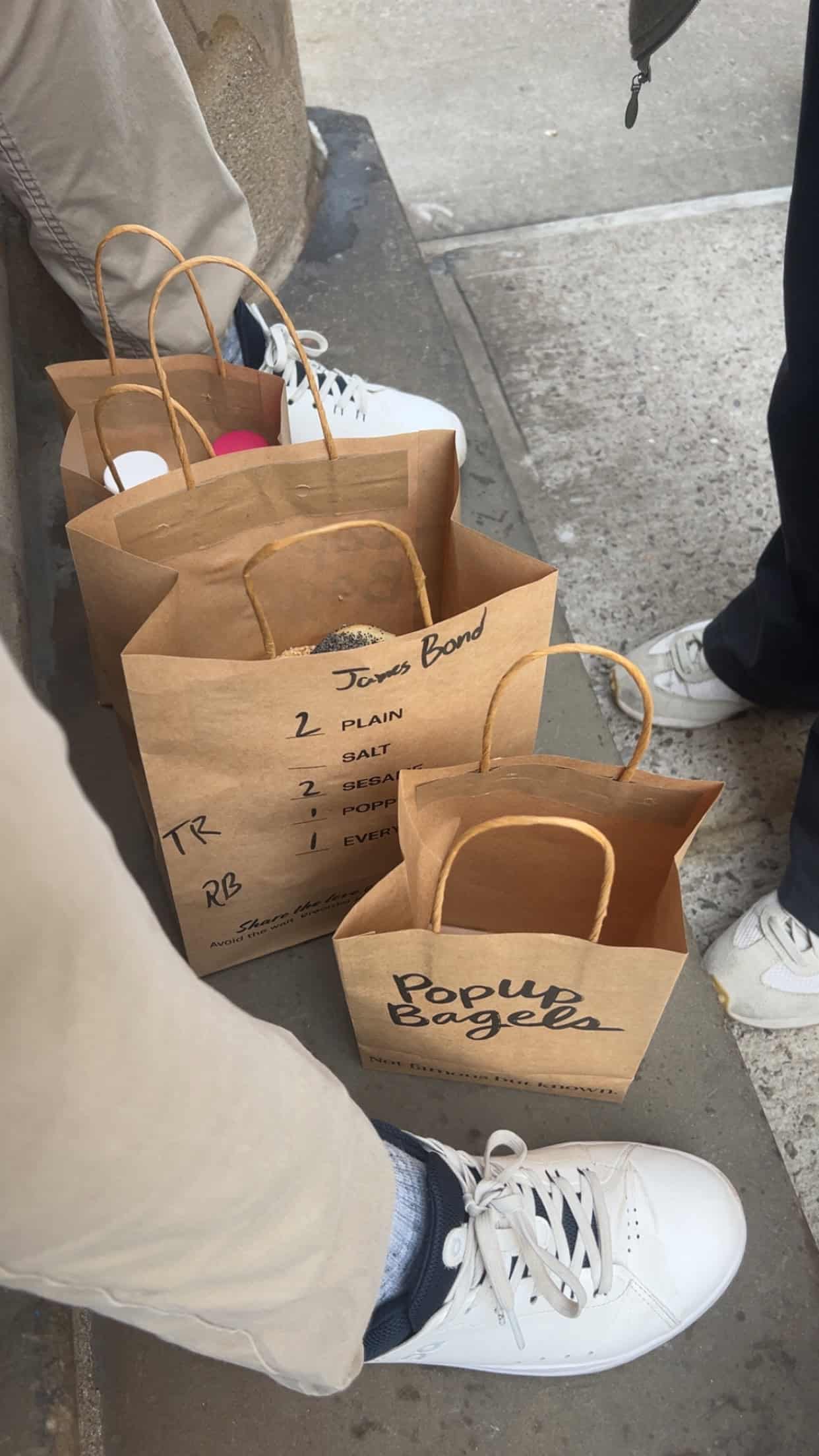 Paper bags on the ground with bagels inside