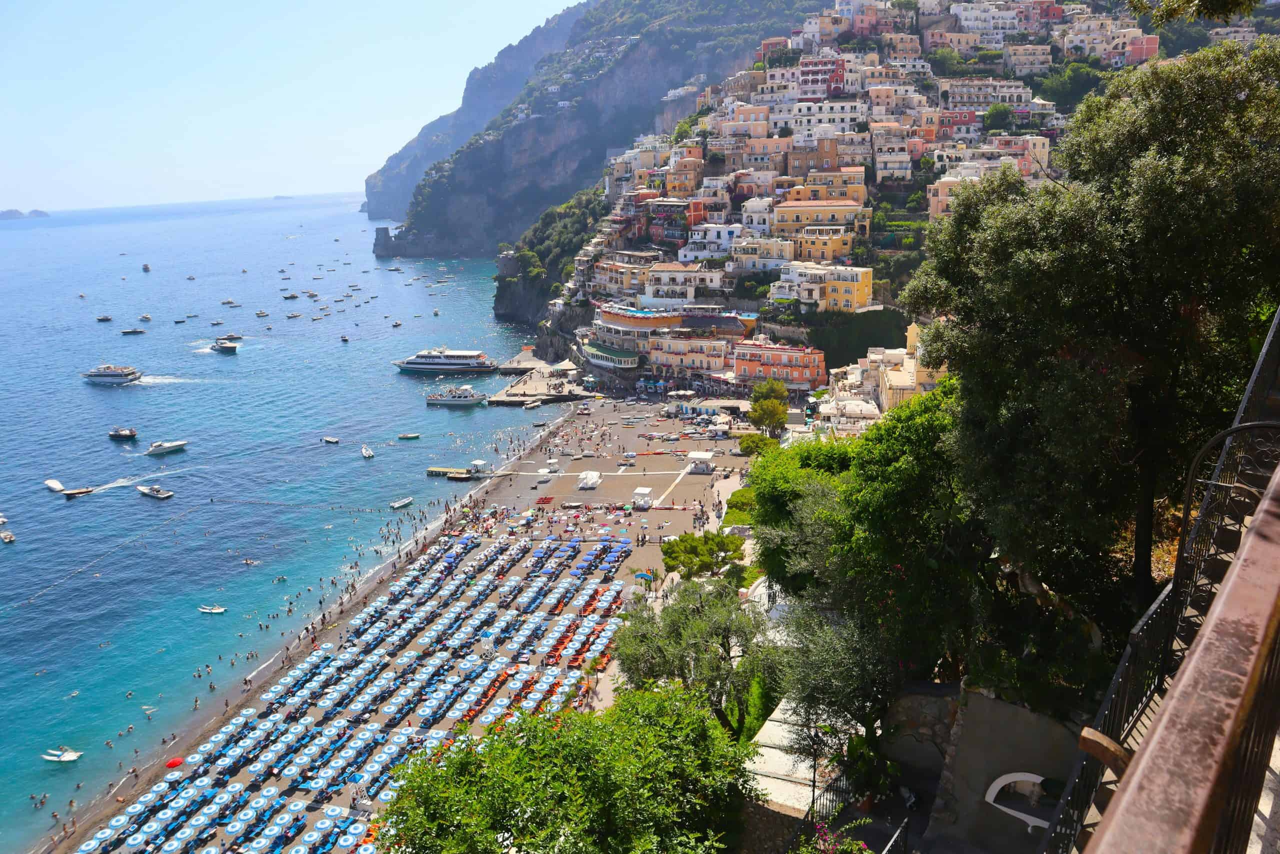 rows of beach chairs with cliffside buildings in the background