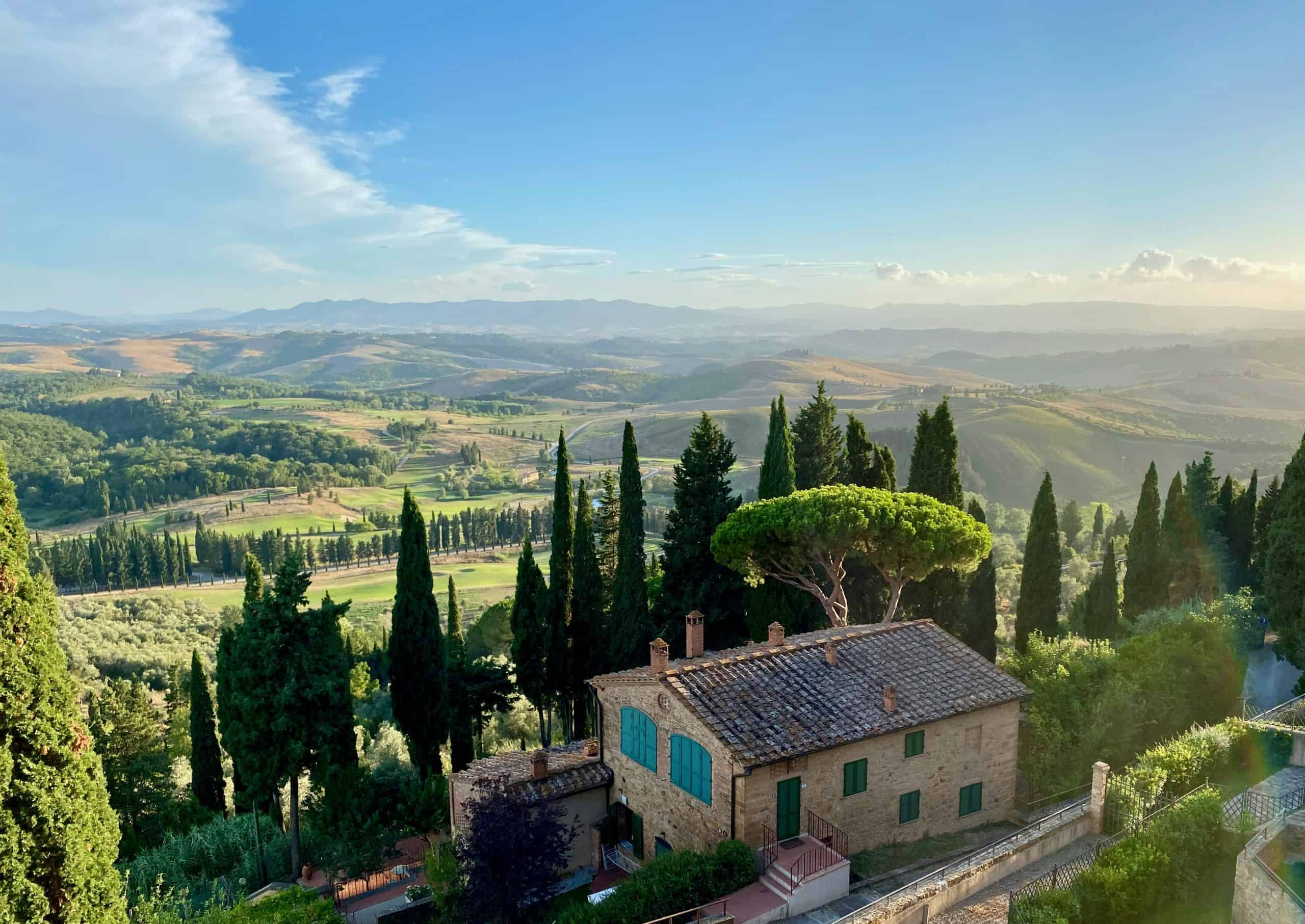 Blue sky above rolling hills of a Tuscany vineyard