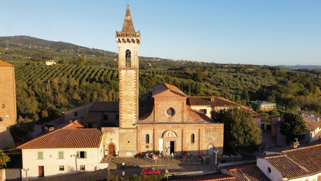 Beautiful Italian countryside with a charming church and rolling hills in the background.