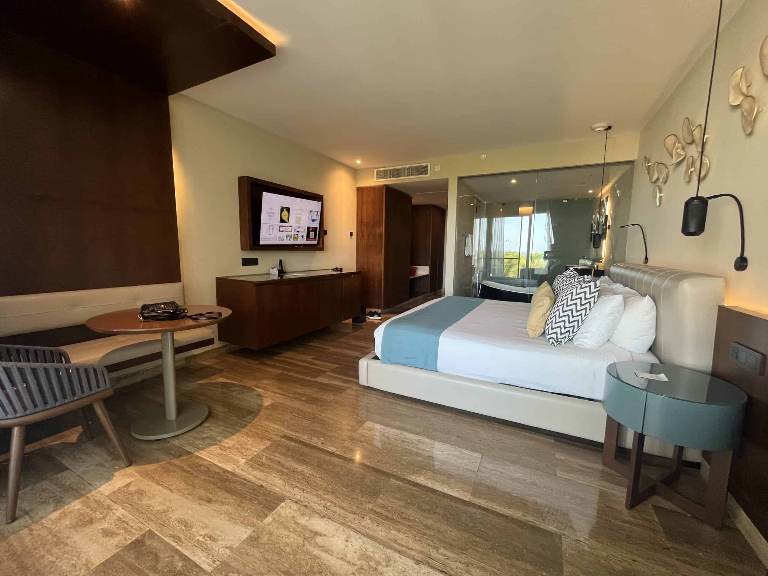 Elegant hotel suite featuring a large bed, modern furnishings.