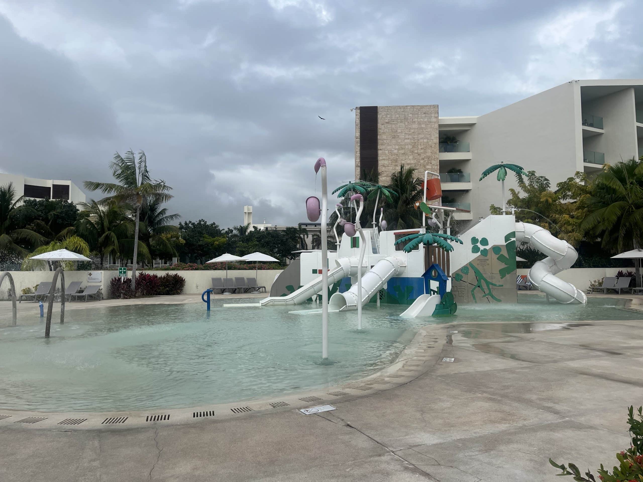 Outdoor splash pad with wading pool and slides
