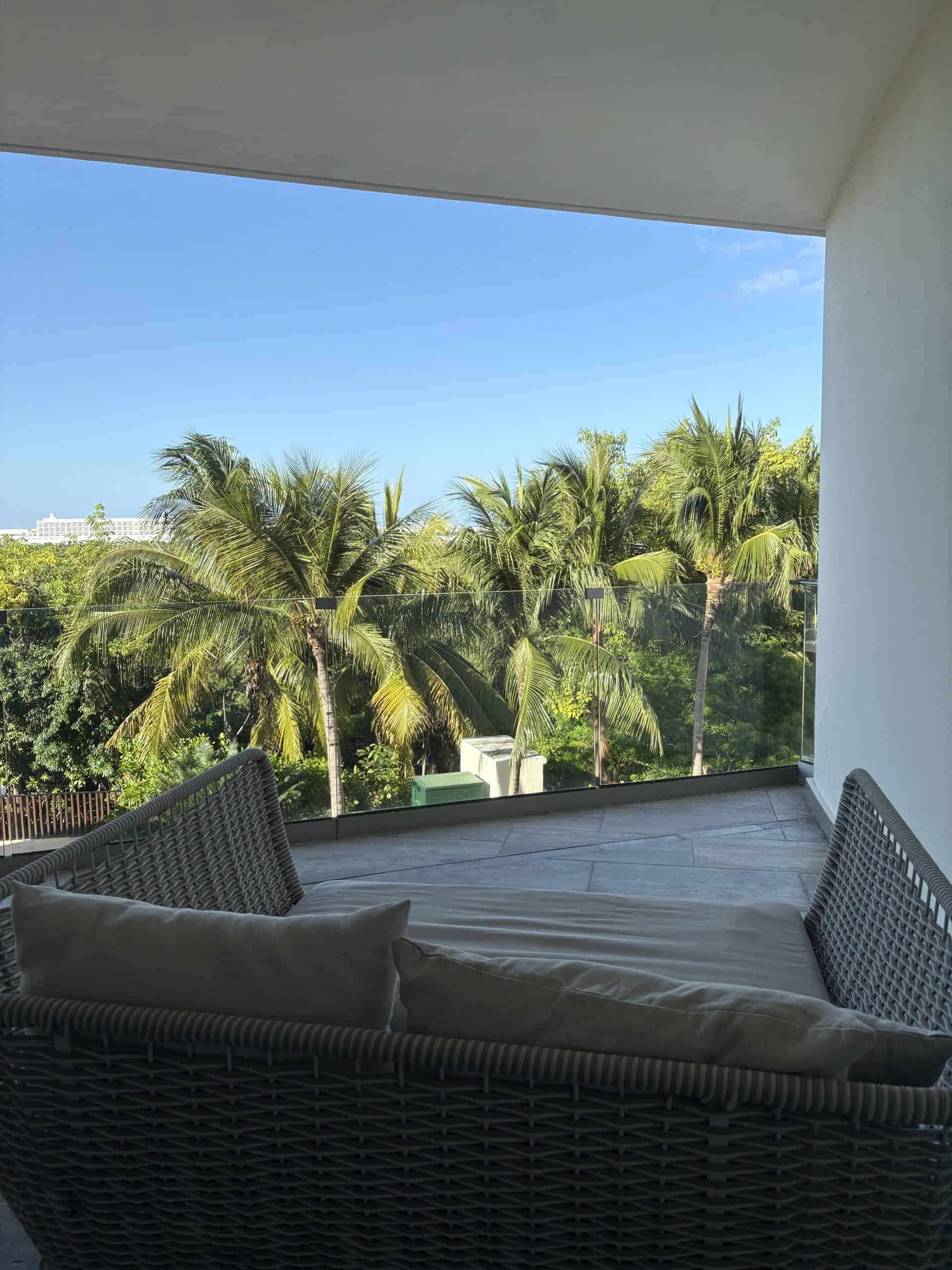Outdoor terrace with couch looking at palm trees