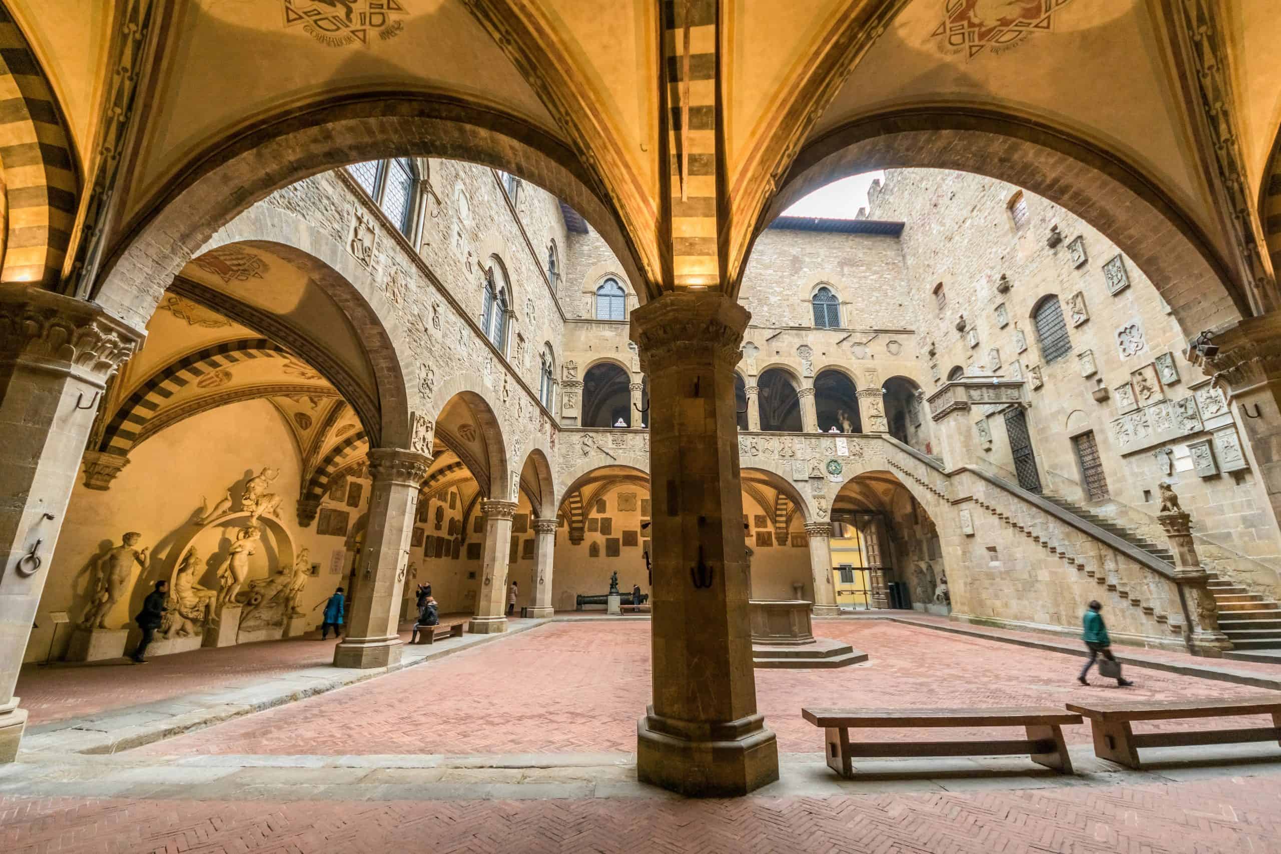 Historic courtyard with stone arches and stairs in an Italian museum