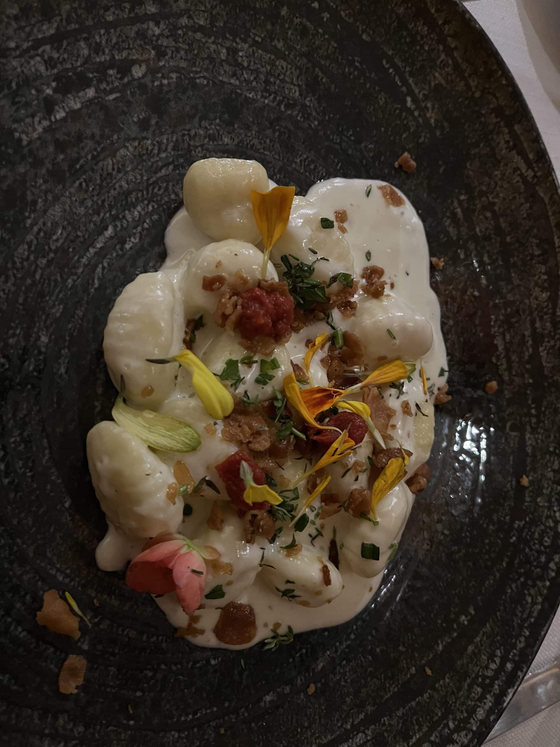 Plate of gnocchi with edible flowers on top