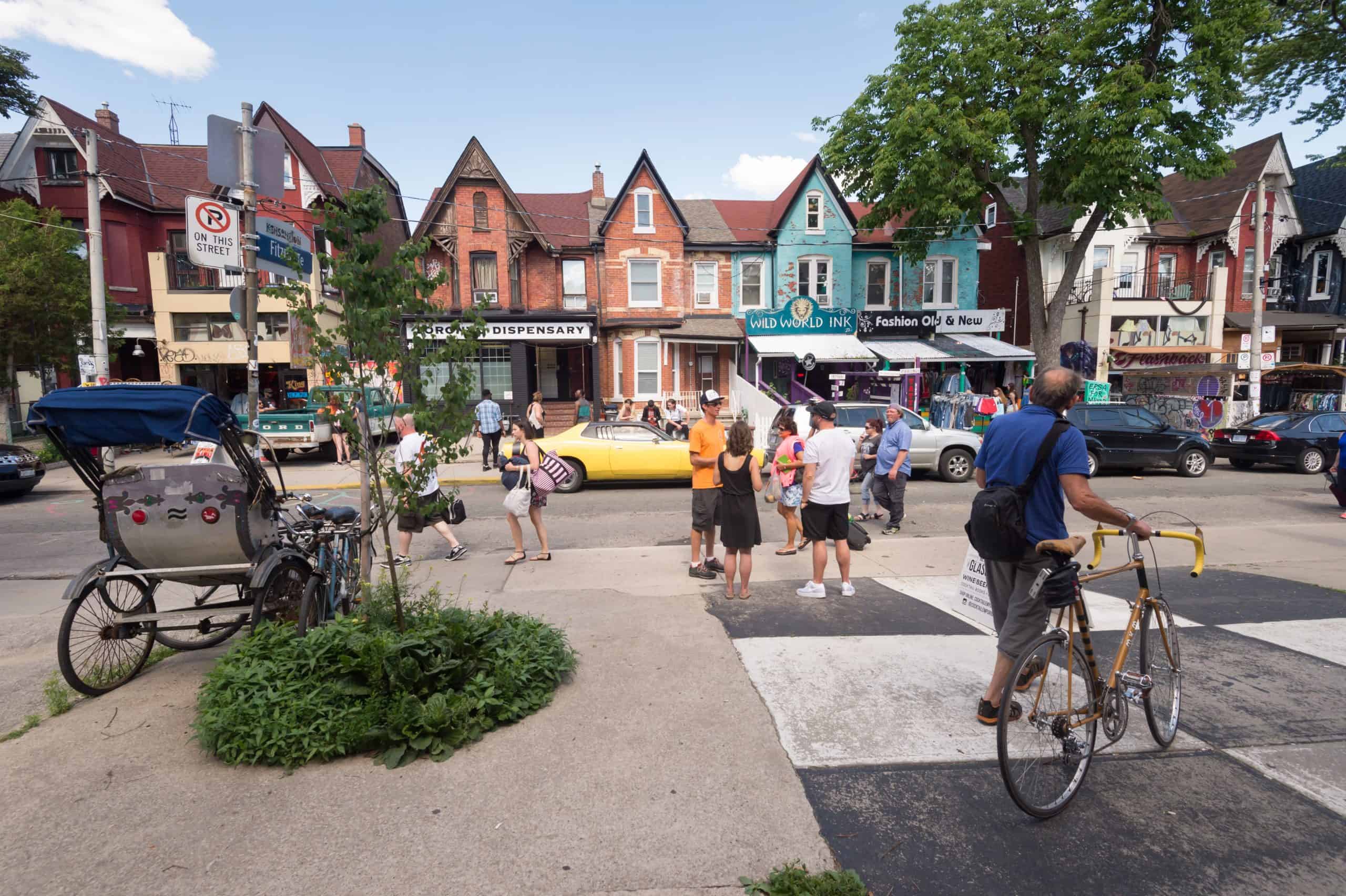 People walking around neighbourhood with colouful houses