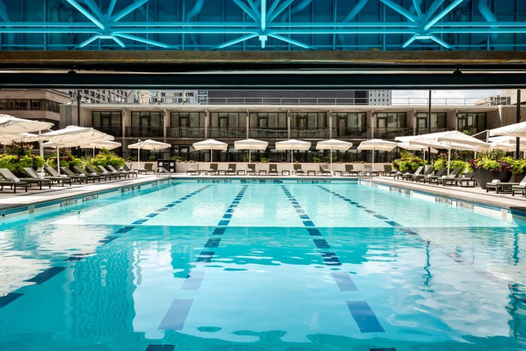 outdoor hotel pool with chairs and umbrellas