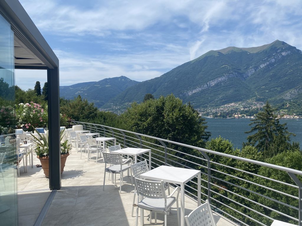 Outdoor dining terrace with lake and mountains in the background