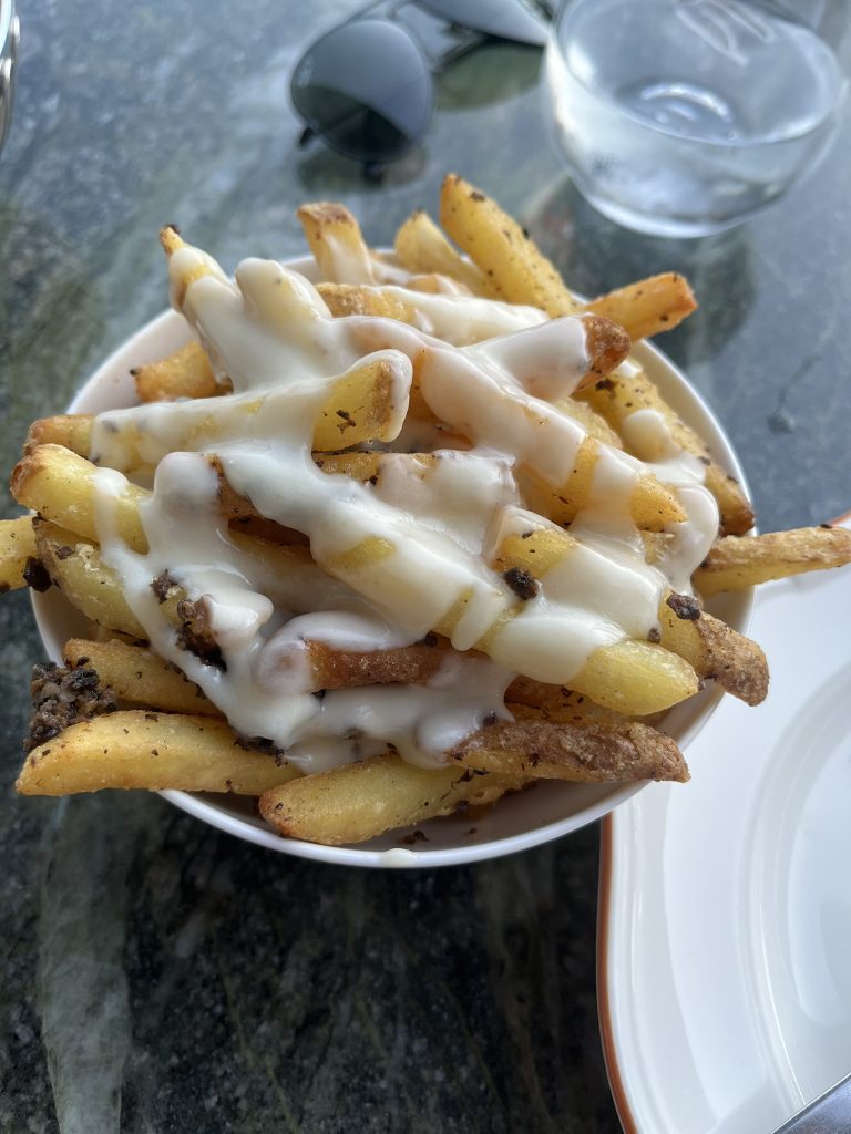 a bowl of french fries with truffle sauce on top