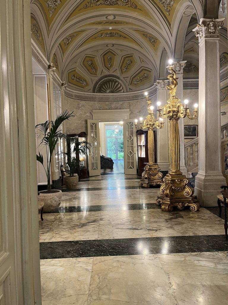 Lobby of hotel with dome ceilings, guilded lights and marble floor